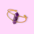 Ascendancy Gems Celestial Amethyst Bracelet with a double-terminated amethyst crystal wrapped in gold wire on a gold cuff.