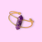 Ascendancy Gems Celestial Amethyst Bracelet with a double-terminated amethyst crystal wrapped in gold wire on a gold cuff.