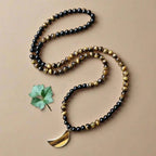 Ascendancy Gems 108-bead mala necklace with black onyx, tiger eye stones, and a crescent moon pendant.