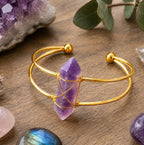 Ascendancy Gems Celestial Amethyst Bracelet with a raw amethyst point wrapped in gold wire on a gold cuff.