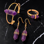 Ascendancy Gems Celestial Amethyst jewelry set featuring a gold-tone cuff bracelet, ring, and dangling crystal earrings.