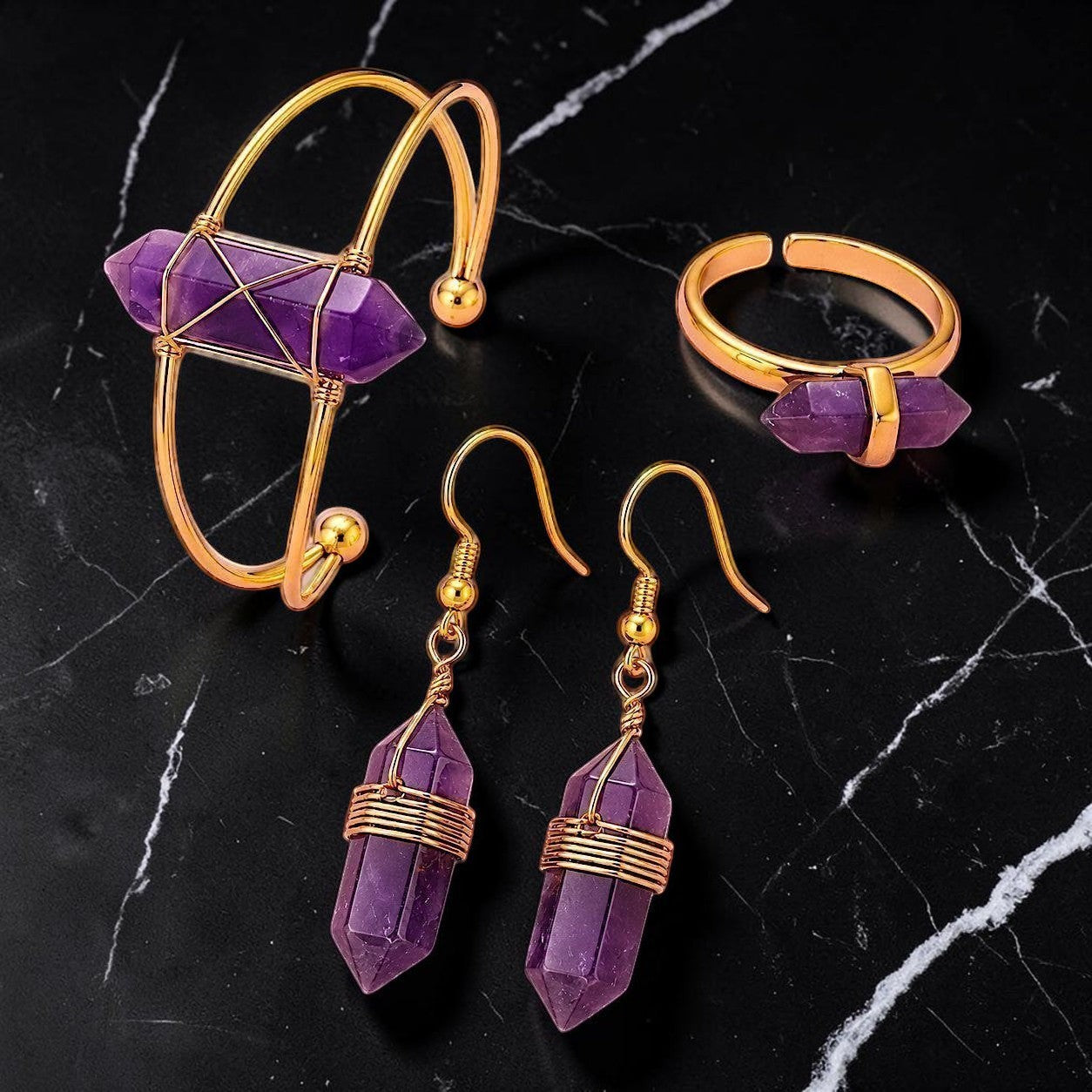 Ascendancy Gems Celestial Amethyst jewelry set featuring a gold-tone cuff bracelet, ring, and dangling crystal earrings.