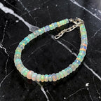 Ascendancy Gems handcrafted Ethiopian Welo opal bead bracelet with vibrant rainbow fire and adjustable silver clasp.