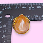 Ascendancy Gems gold-filled ring with a large, multifaceted, peachy-pink teardrop gemstone.