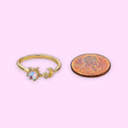 Ascendancy Gems gold-plated adjustable ring with a moonstone, star setting, and crescent moon, shown next to a penny.