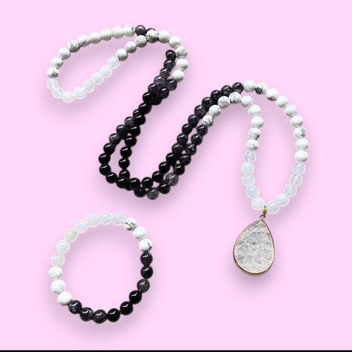 Ascendancy Gems Awakening Mala Set: 108-bead necklace & bracelet with white howlite, black onyx, and quartz, featuring a teardrop quartz pendant.