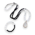 Ascendancy Gems Awakening Mala Set: 108-bead necklace & bracelet with white howlite, black onyx, and quartz, featuring a teardrop quartz pendant.