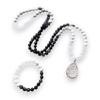 Ascendancy Gems Awakening Mala Set: 108-bead necklace & bracelet with white howlite, black onyx, and quartz, featuring a teardrop quartz pendant.