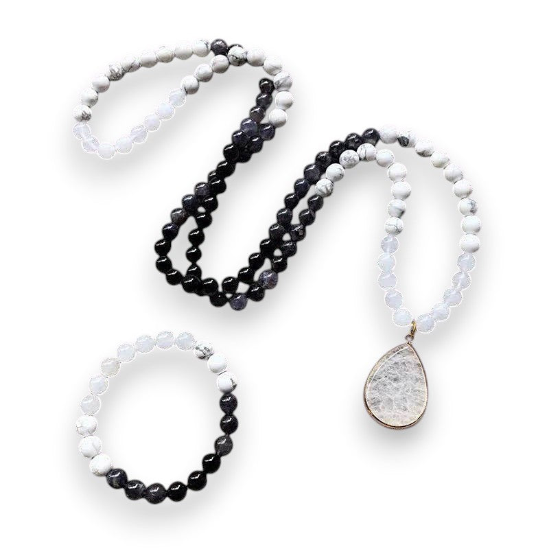 Ascendancy Gems Awakening Mala Set: 108-bead necklace & bracelet with white howlite, black onyx, and quartz, featuring a teardrop quartz pendant.