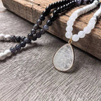 Ascendancy Gems Awakening Mala Set: 108-bead necklace & bracelet with white howlite, black onyx, and quartz teardrop pendant.