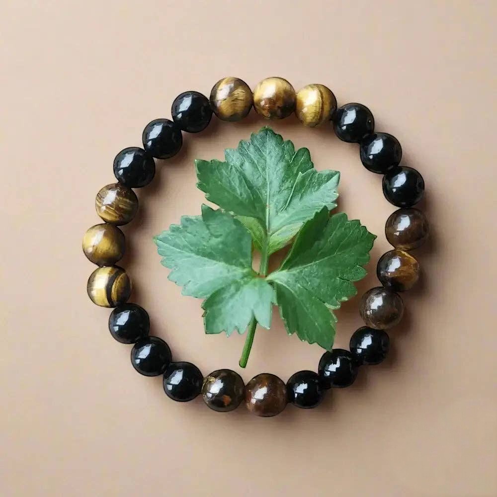Ascendancy Gems handcrafted mala bracelet with alternating natural black onyx and tiger eye beads on beige background