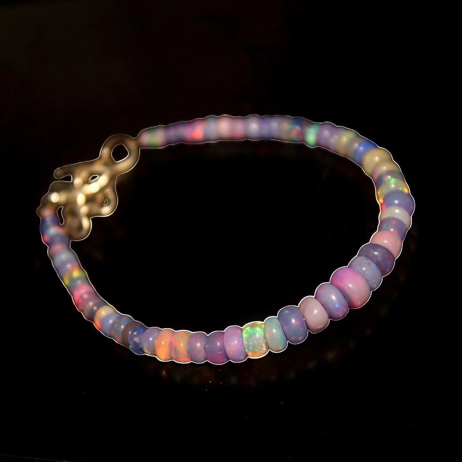 Ascendancy Gems one-of-a-kind purple smoked opal beaded bracelet with flashes of green, orange, red, and blue fire.