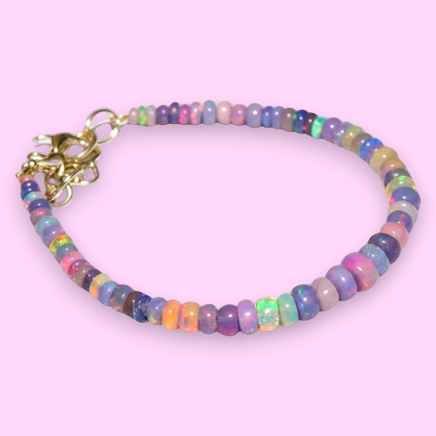 Ascendancy Gems one-of-a-kind purple smoked opal beaded bracelet with flashes of green, orange, red, and blue fire. 6 inches.