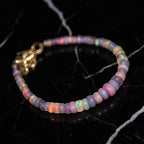 Ascendancy Gems one-of-a-kind purple smoked opal beaded bracelet with flashes of green, orange, red, and blue fire.
