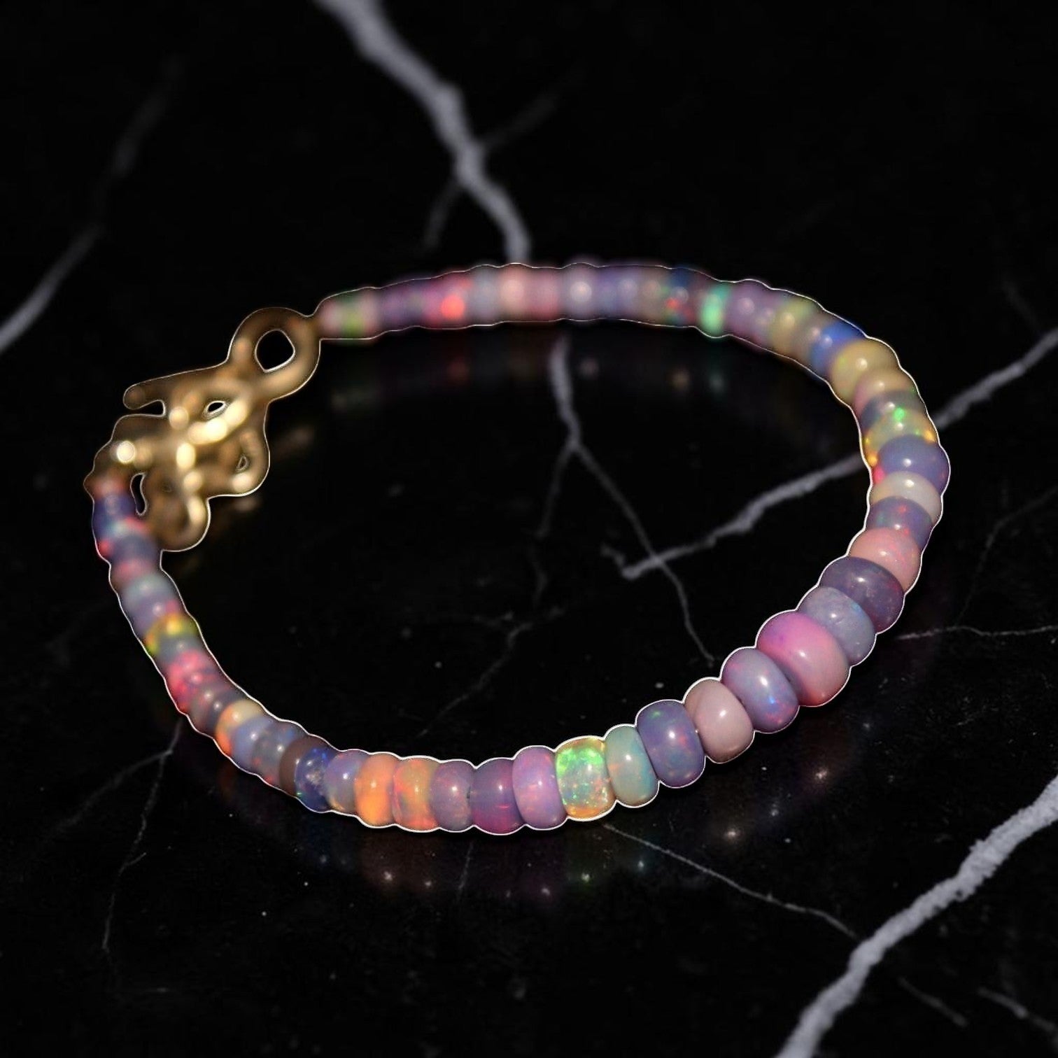Ascendancy Gems one-of-a-kind purple smoked opal beaded bracelet with flashes of green, orange, red, and blue fire.