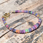 Ascendancy Gems one-of-a-kind bracelet featuring iridescent purple smoked Ethiopian fire opal beads with gold clasp.