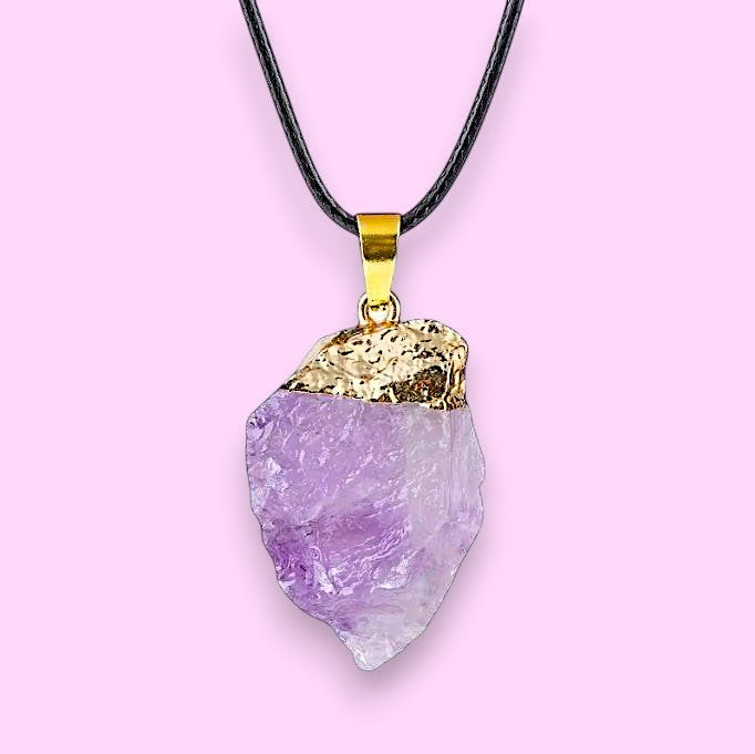 Ascendancy Gems raw amethyst crystal pendant necklace with gold cap and black cord.
