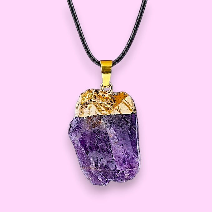 Ascendancy Gems raw amethyst crystal pendant necklace with gold cap and black cord.