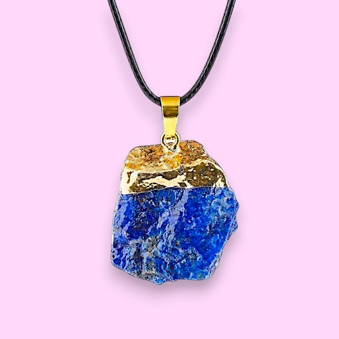 Ascendancy Gems raw lapis lazuli crystal necklace with gold cap and black cord. Natural, irregular shape.