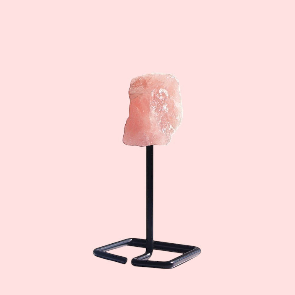 Ascendancy Gems raw rose quartz crystal on a minimalist black metal stand, approx. 4 inches tall.