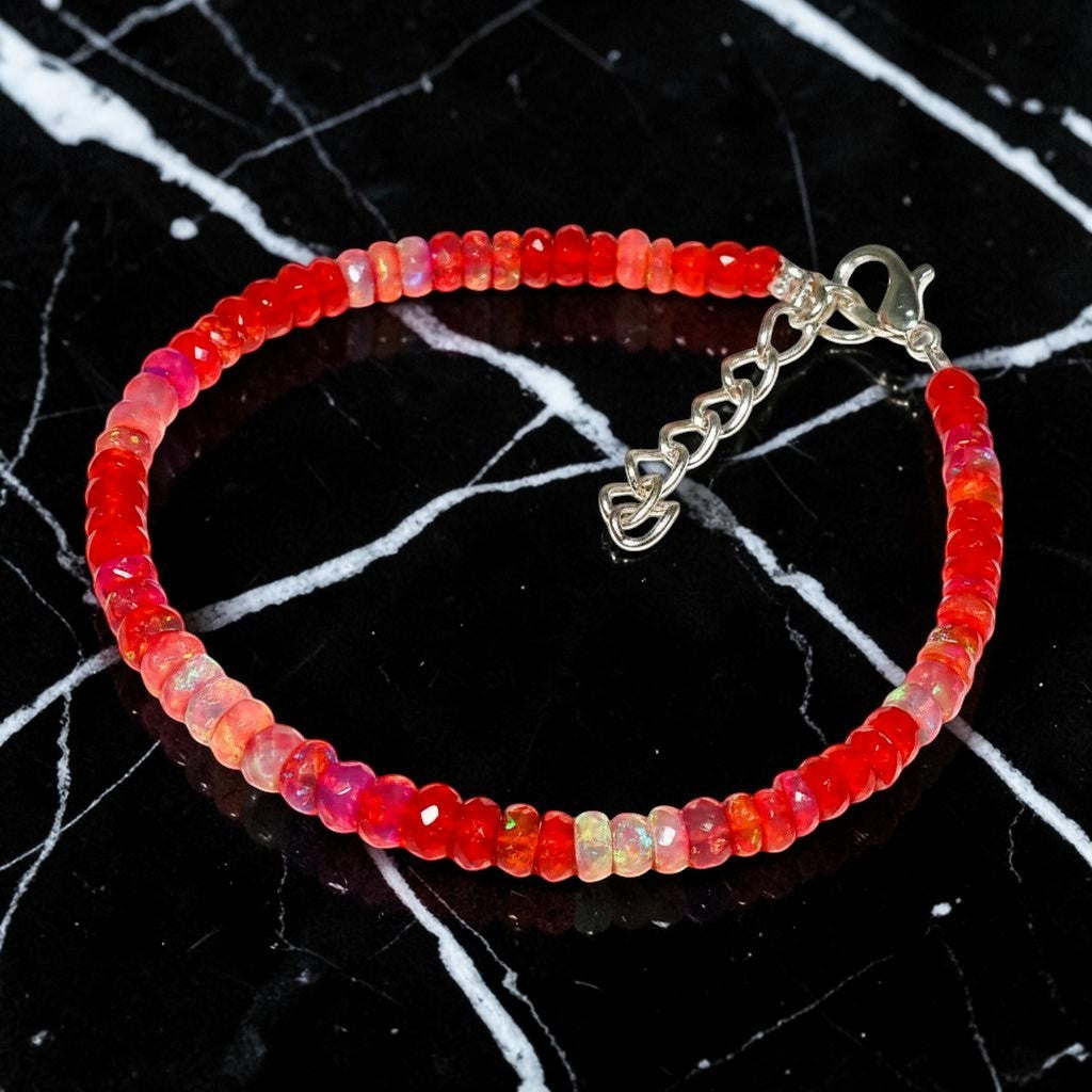 Ascendancy Gems handcrafted bracelet featuring faceted red Ethiopian Welo fire opal beads with a silver clasp.