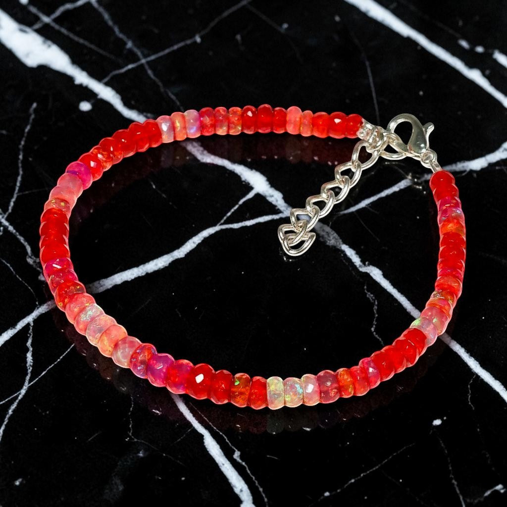 Ascendancy Gems handcrafted bracelet featuring faceted red Ethiopian Welo fire opal beads with a silver clasp.